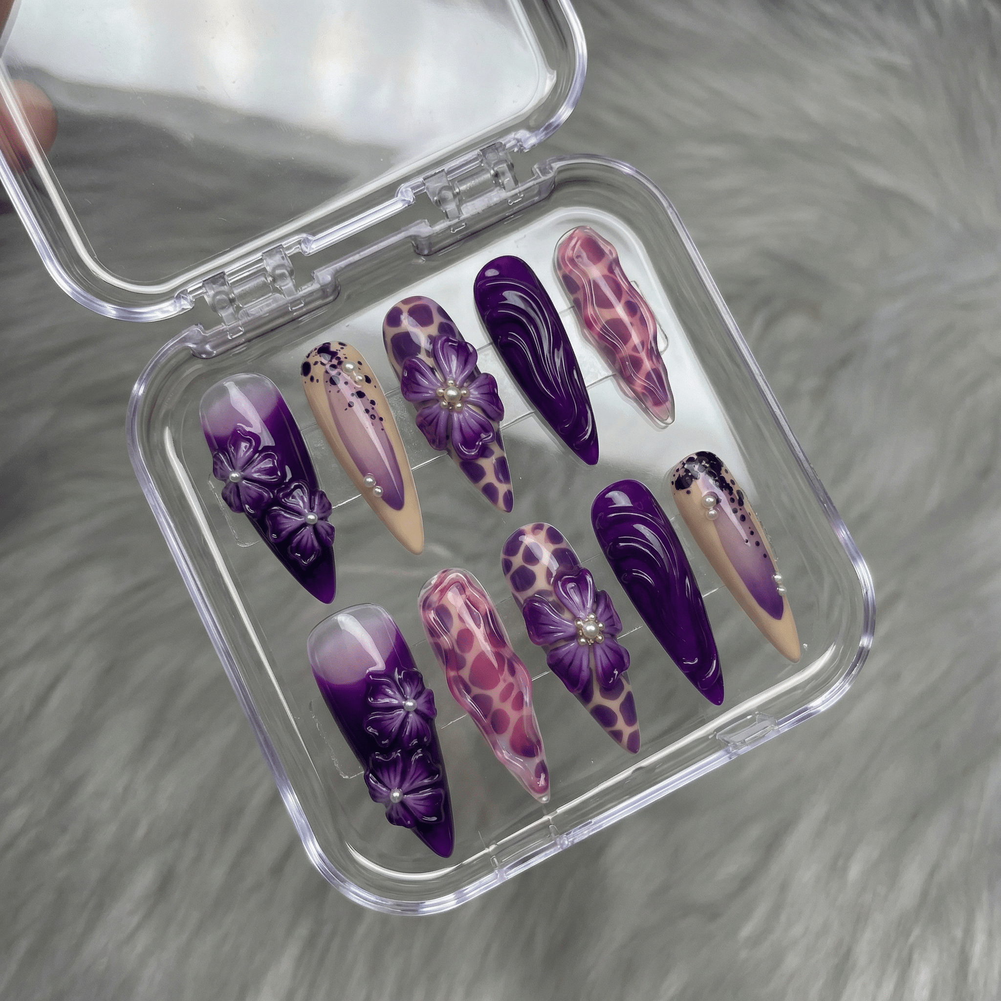 Purple Petals press-on nails worn on hand – almond shape by Handora