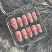 Royal Bloom press-on nails worn on hand – almond shape by Handora