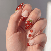 Ruby Berry press-on nails worn on hand – almond shape by Handora
