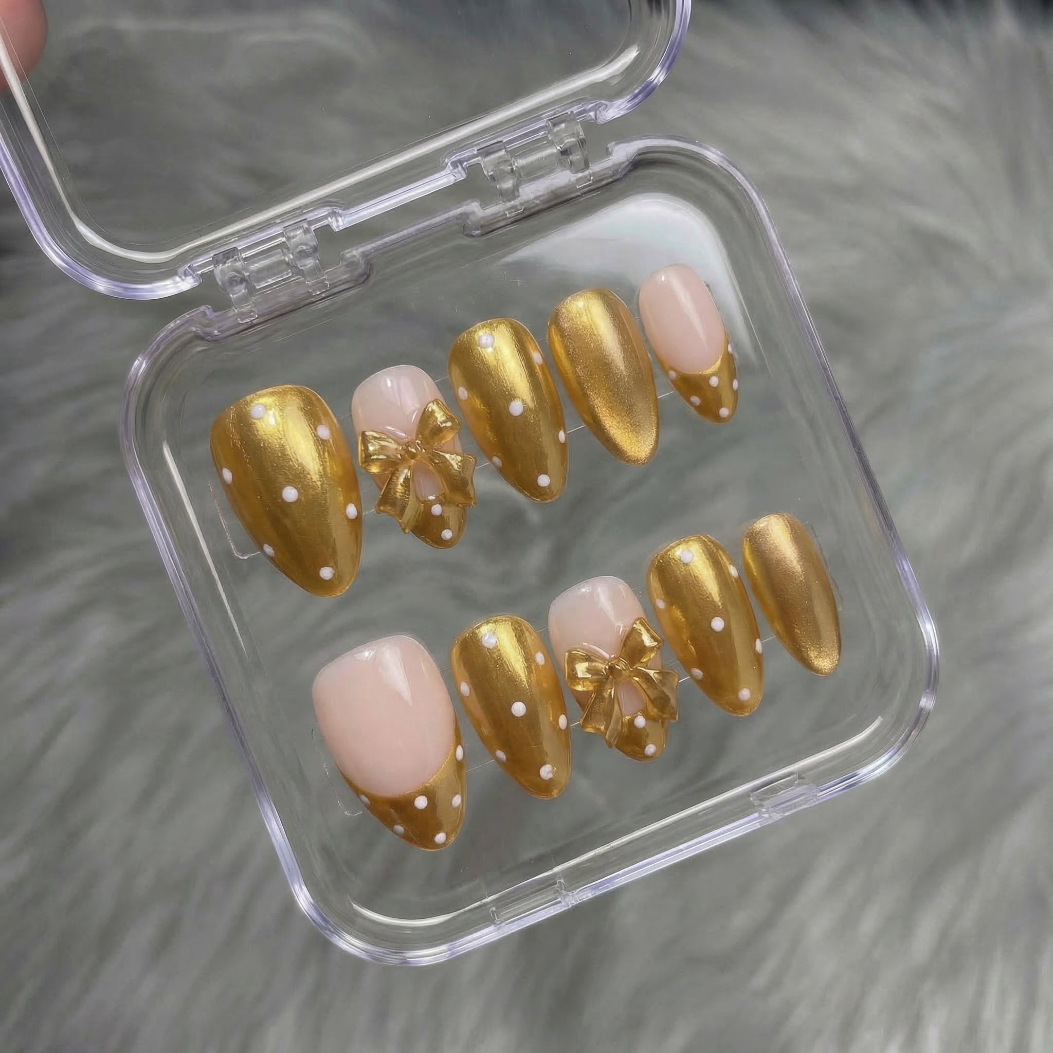 Ruby Polka press-on nails worn on hand – almond shape by Handora