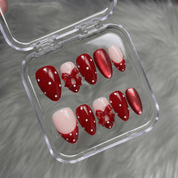 Ruby Polka press-on nails worn on hand – almond shape by Handora