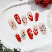 Rudolph’s Kiss press-on nails worn on hand – almond shape by Handora