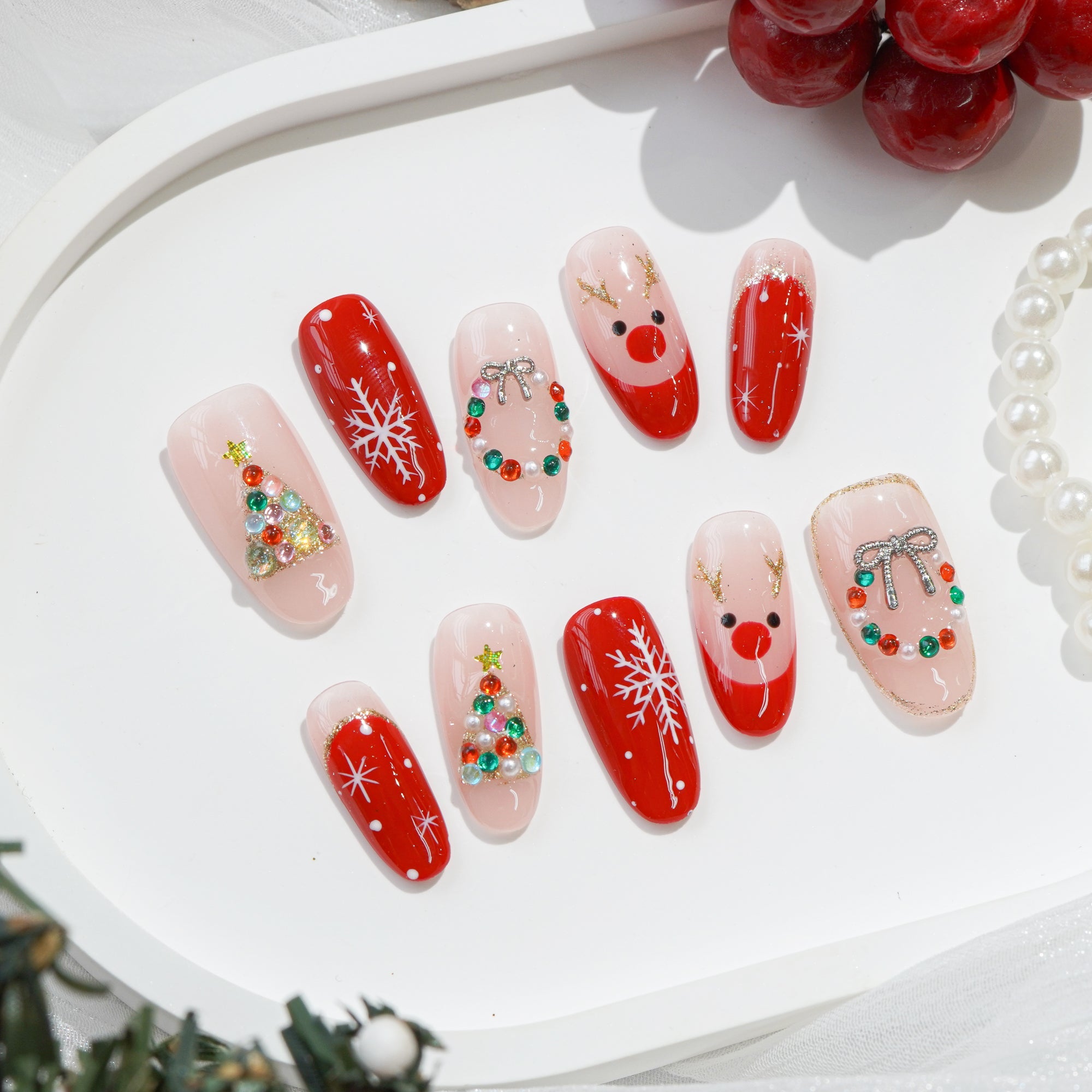 Rudolph’s Kiss press-on nails worn on hand – almond shape by Handora
