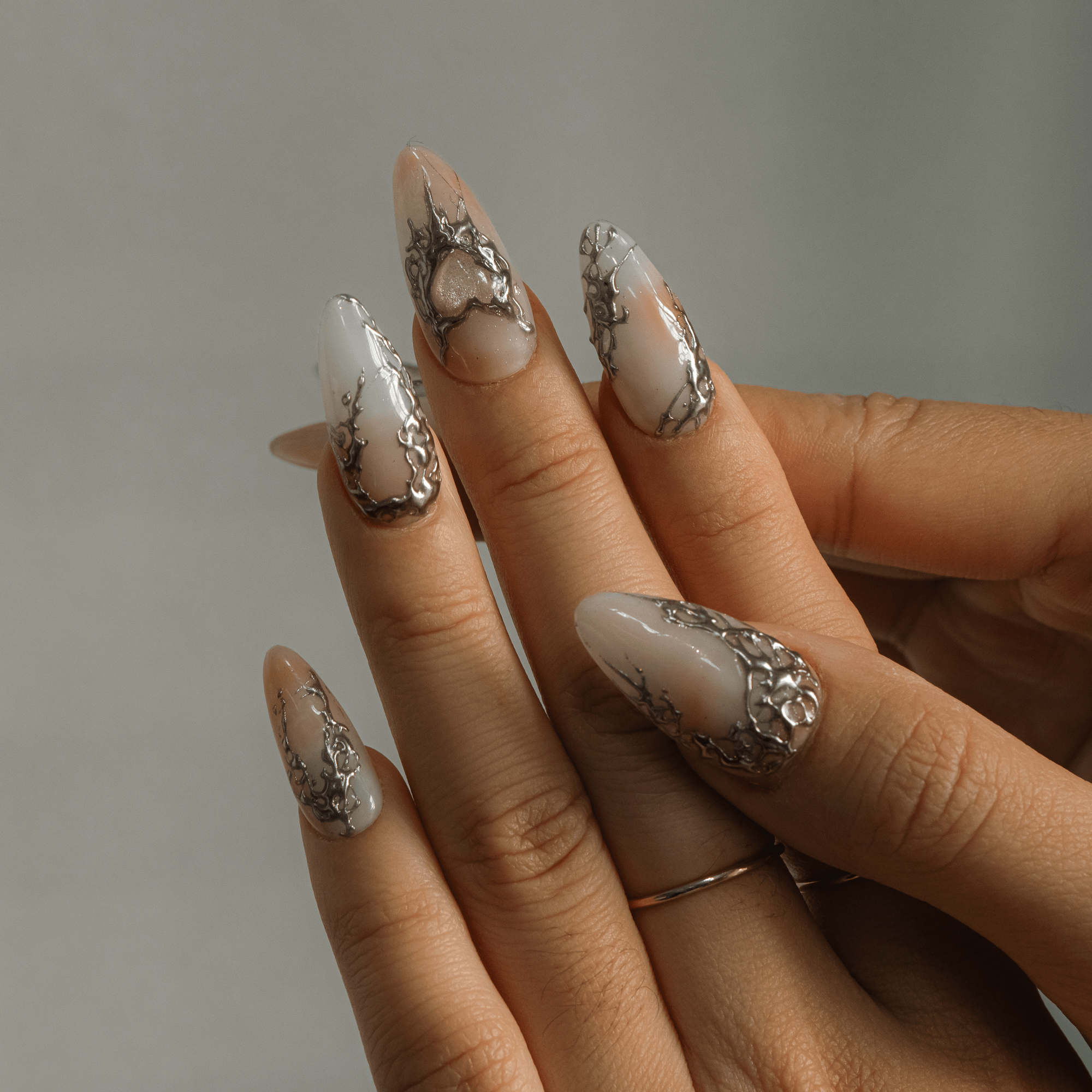 Silver Aura almond press-on nails – design close-up by Handora