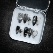 Silver Gothic press-on nails worn on hand – almond shape by Handora