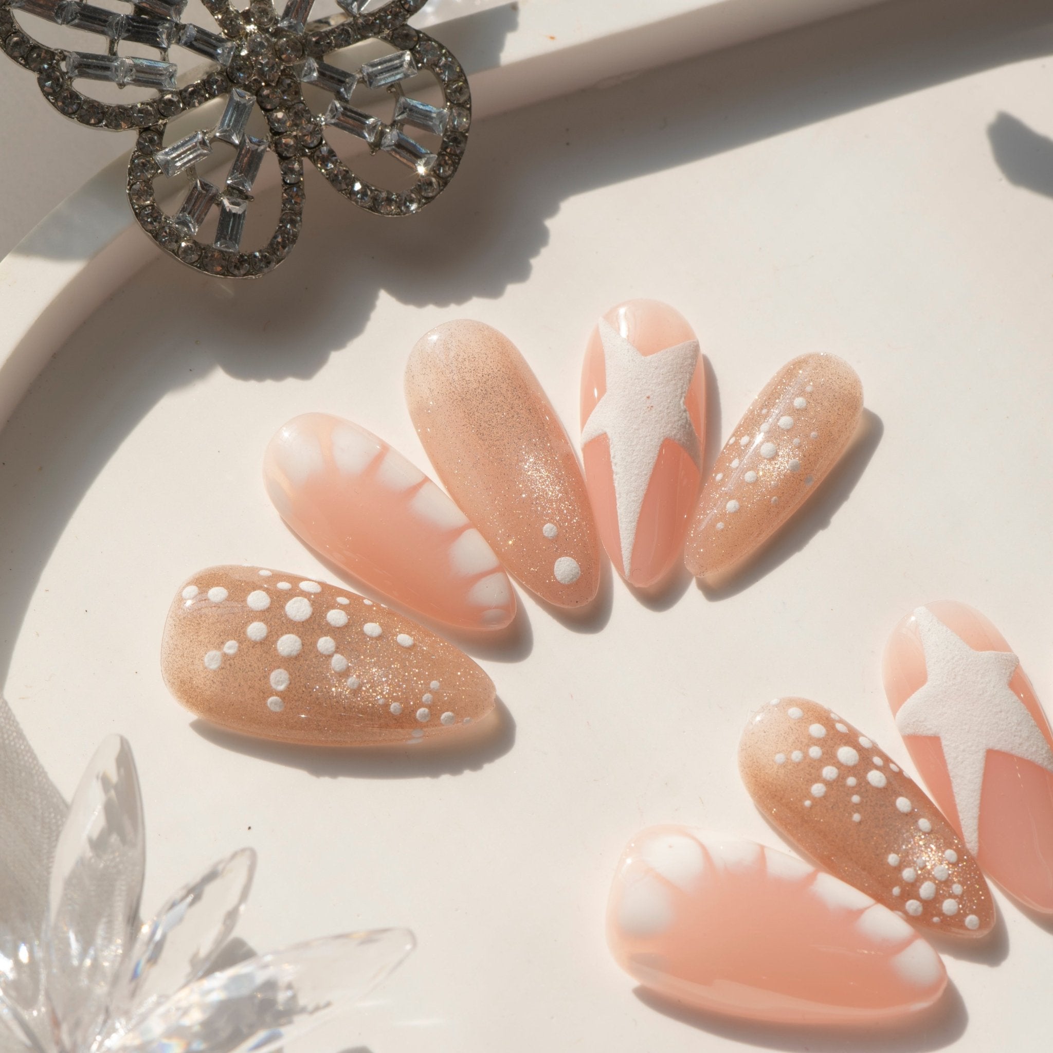Star Snow press-on nails worn on hand – almond shape by Handora