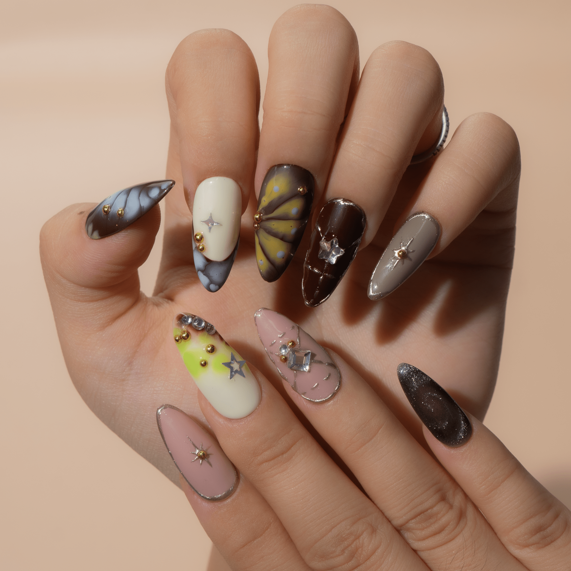 Starfall Dream press-on nails worn on hand – almond shape by Handora