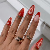 Strawberry Kiss press-on nails worn on hand – almond shape by Handora