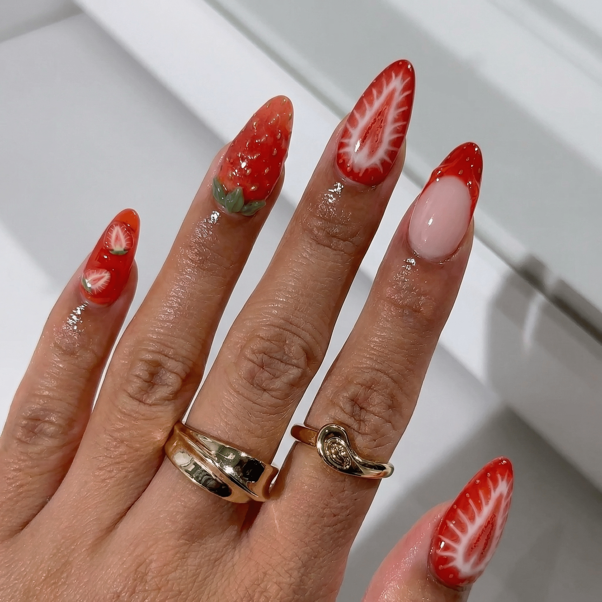 Strawberry Kiss press-on nails worn on hand – almond shape by Handora