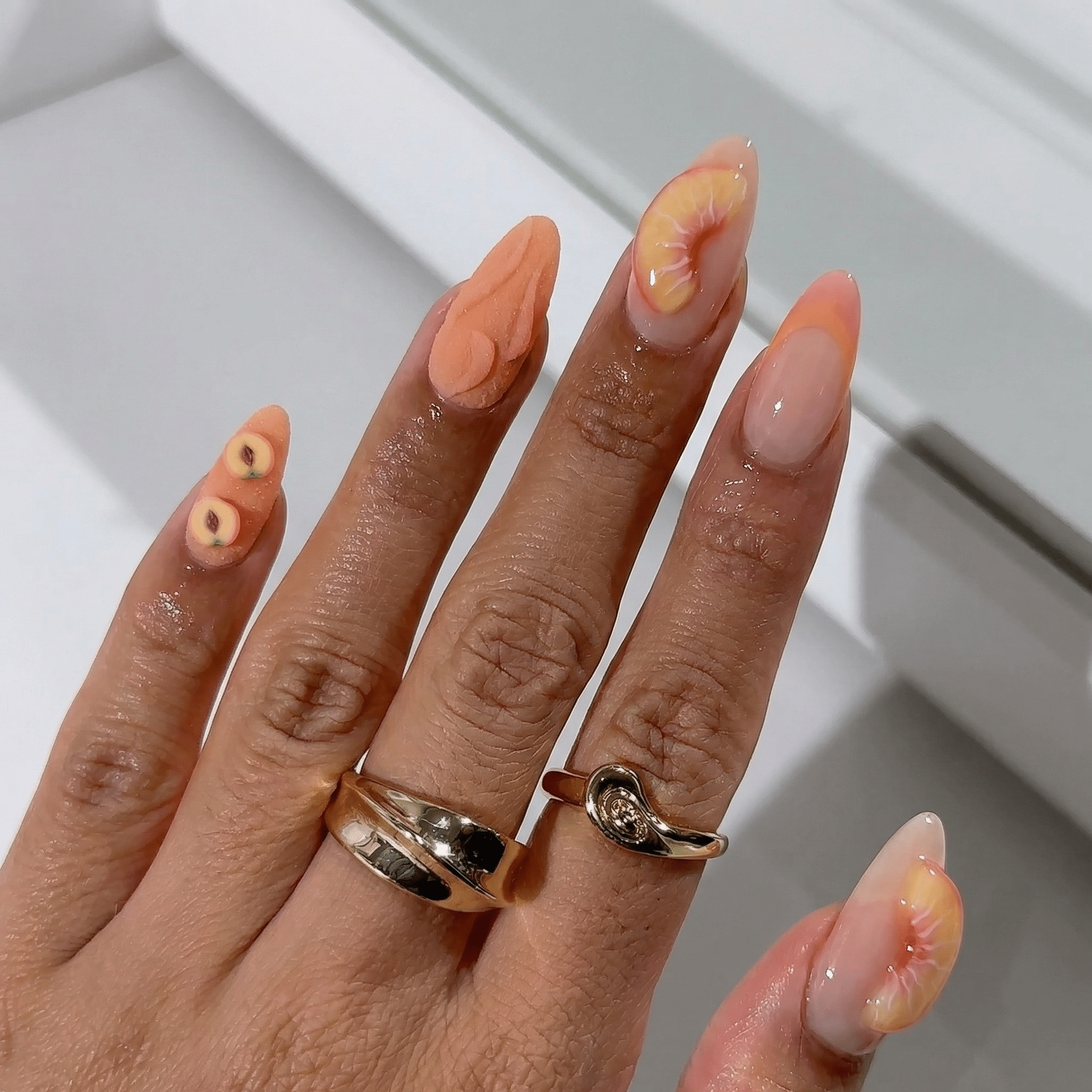 Sunset Citrus press-on nails worn on hand – almond shape by Handora