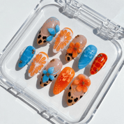 Sunset Safari press-on nails worn on hand – almond shape by Handora