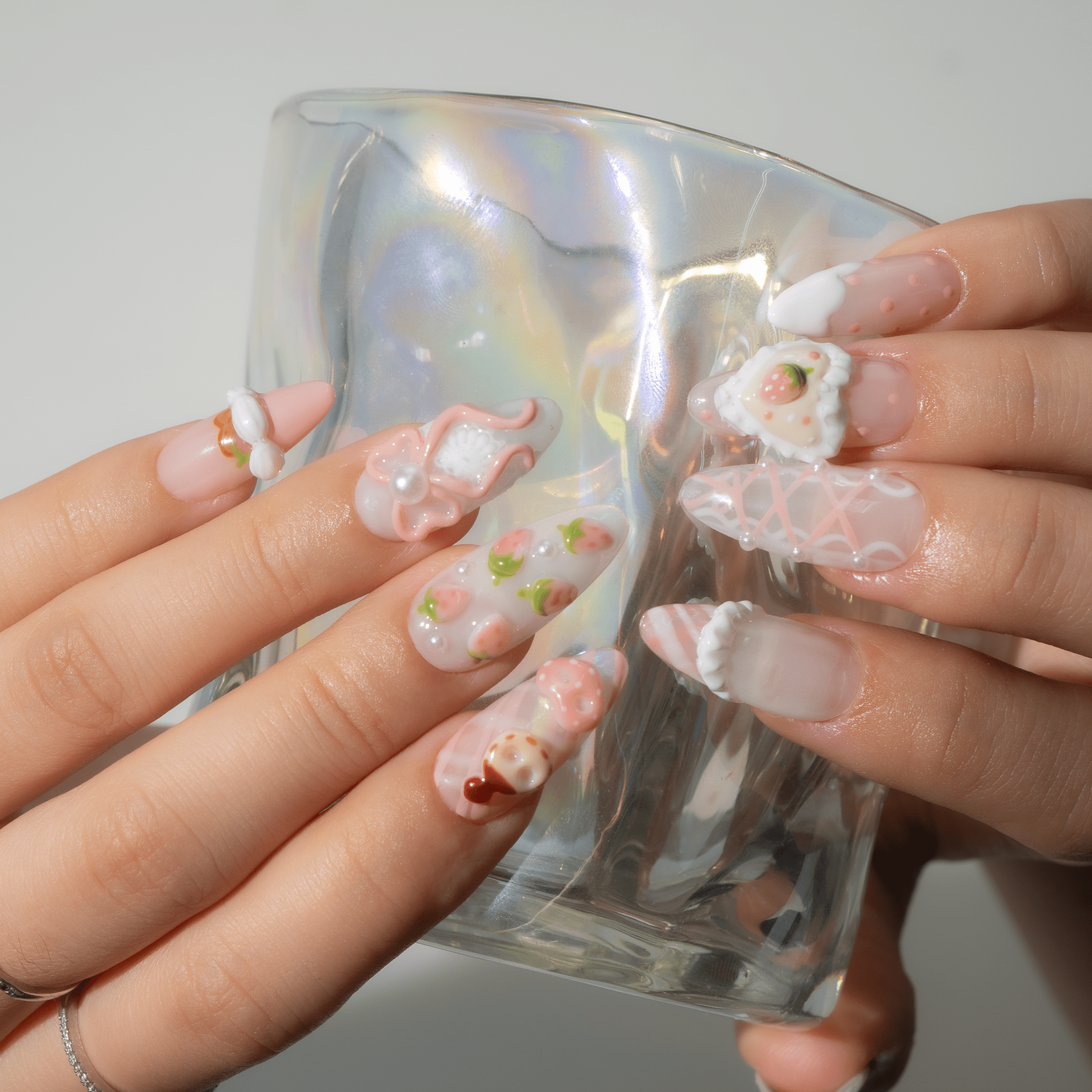 Sweet Berry press-on nails worn on hand – almond shape by Handora