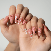 Sweet Spooky press-on nails worn on hand – almond shape by Handora