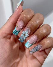 Teal Bloom press-on nails worn on hand – almond shape by Handora