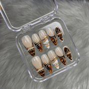 Wild Amber press-on nails worn on hand – almond shape by Handora